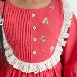 "Close-up of the pleated and embroidery details in the coral pleated yoke embroidered cotton long sleeves dress."