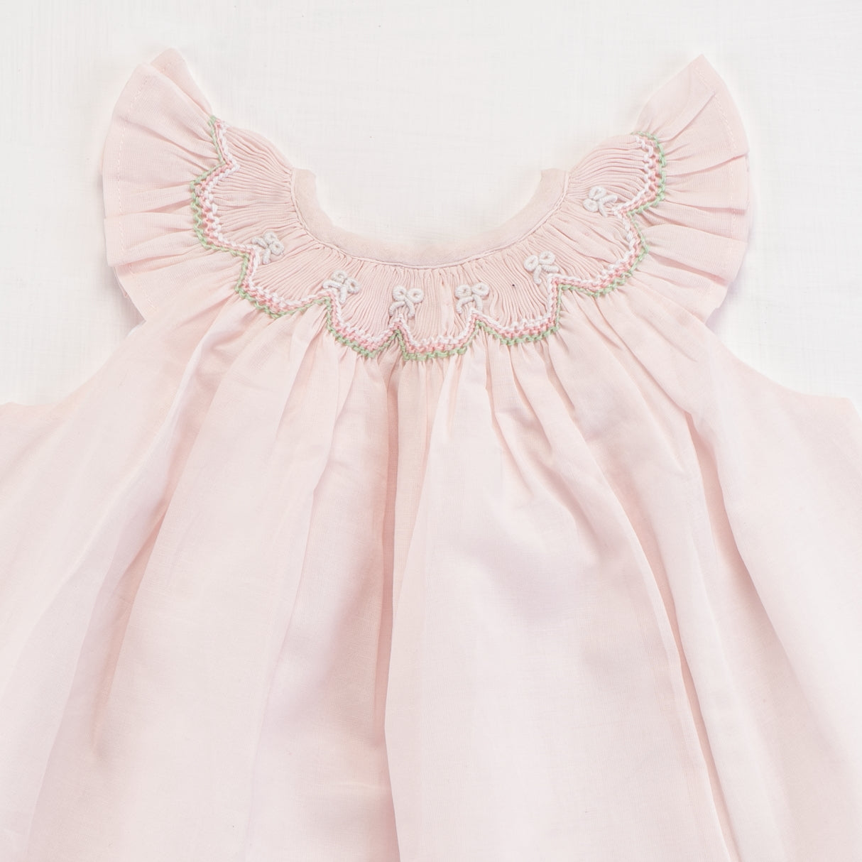 Close-up of the smocking detail of pink bishop