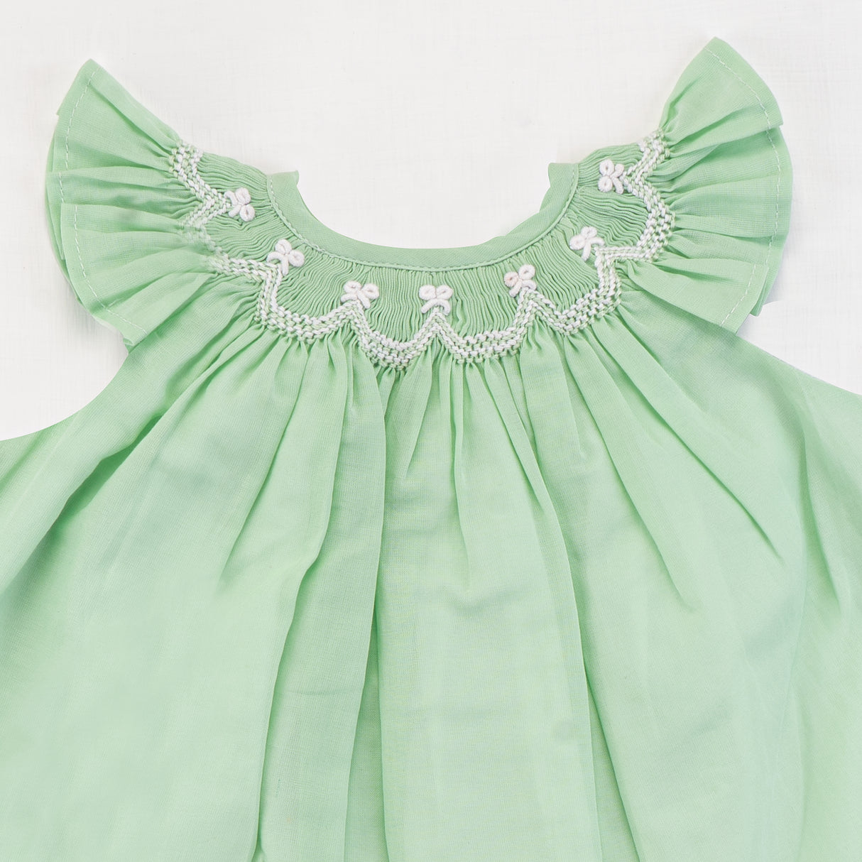 Close-up of the smocking detail of green bishop
