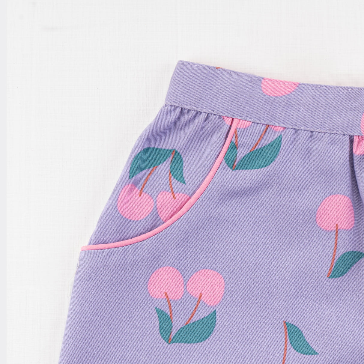 Close-up of the pocket in lilac & cherry print shorts