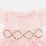 Close-up of the smocking and embroidery details of the pink smocked girls dress
