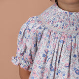 close-up of hand-smocked embroidery on the neckline with ric rac trim on the sleeves