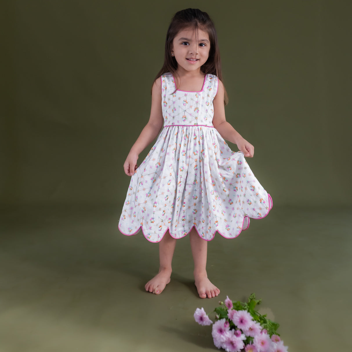 a little girl dressed in hakoba pink scallop hem dress