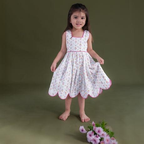 a little girl dressed in hakoba pink scallop hem dress