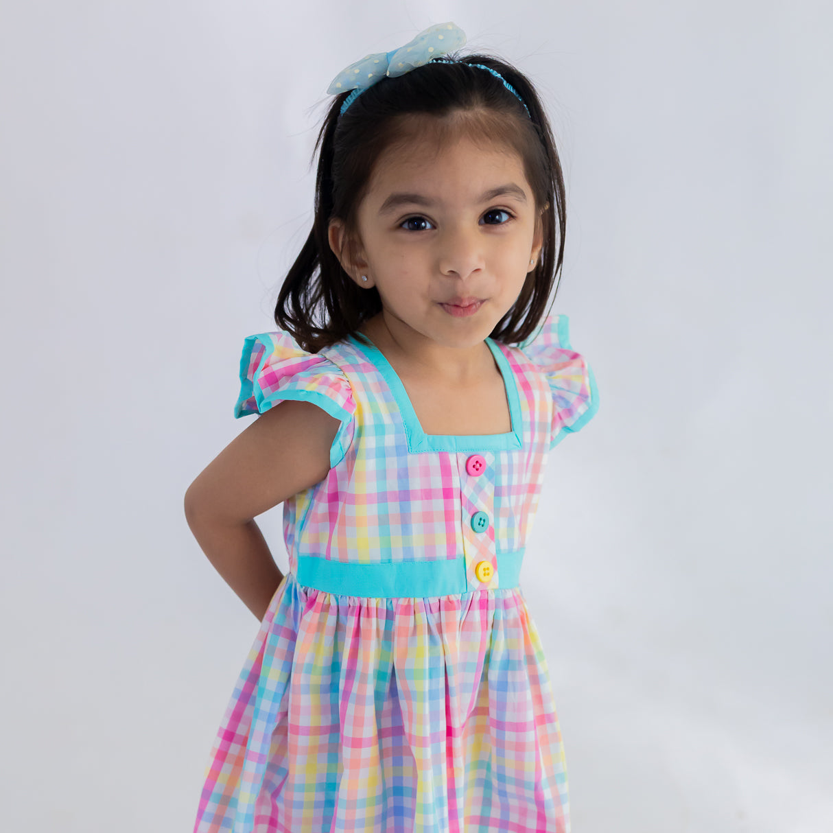 closeup of ruffle sleeves and bodice of multicolour plaid dress
