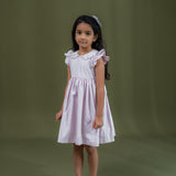 side view of girl dressed in pink dot print dress