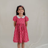 a little girl dressed in red vintage rose print dress with embroidered collar
