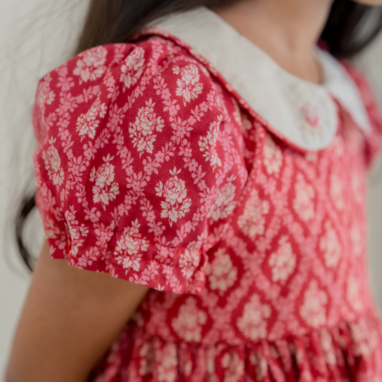 closeup of the puffed sleeves of the red vintage rose print dress