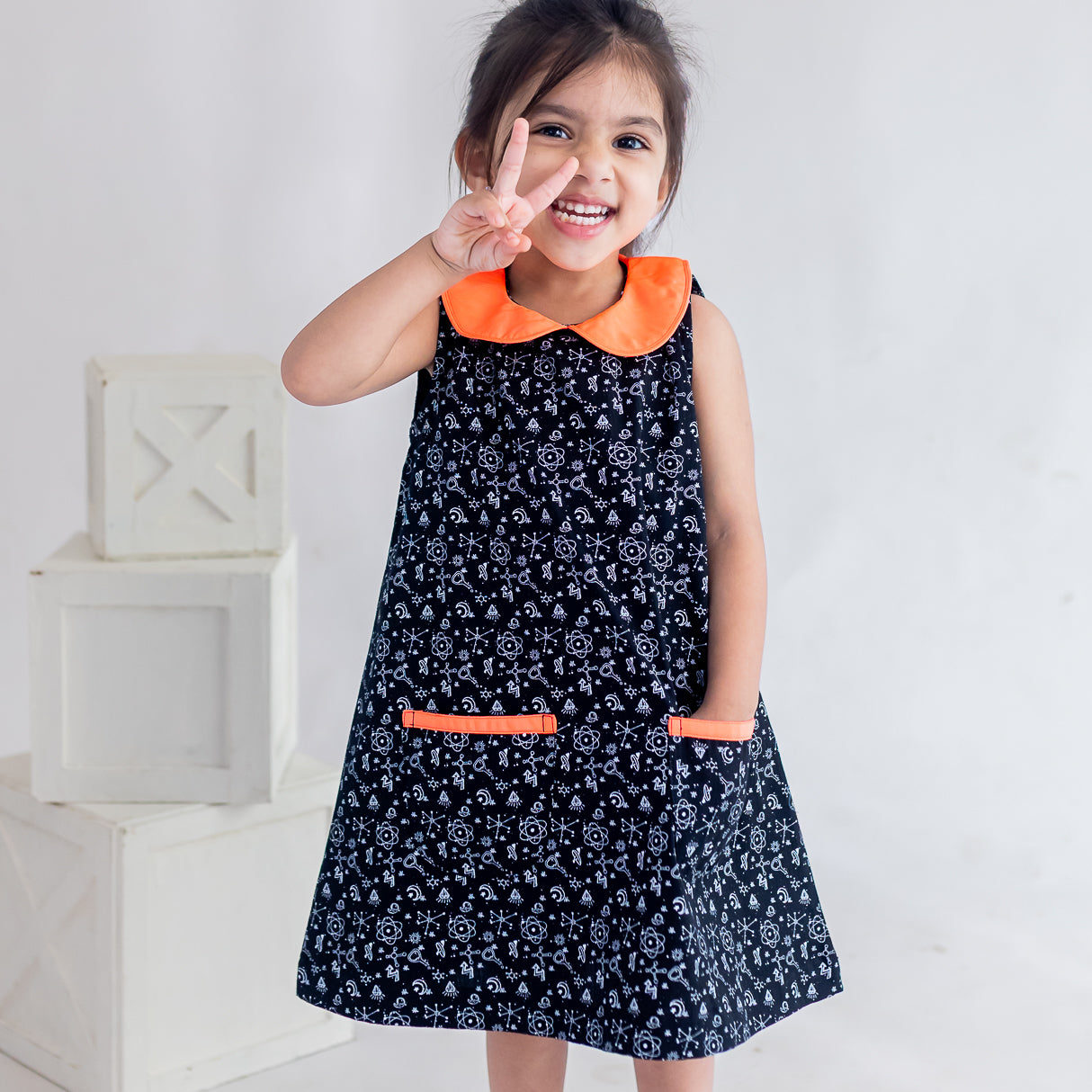 a little girl dressed in black science print a line dress