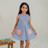 a little girl dressed in blue print a line dress