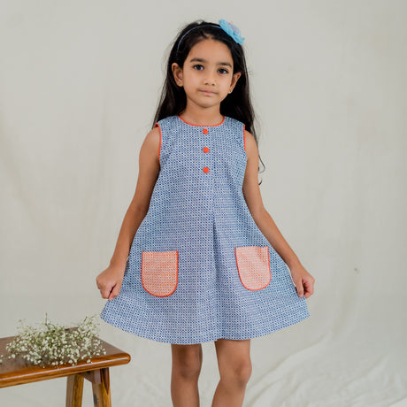 a little girl dressed in blue print a line dress