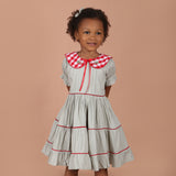 girl wearing vintage red gingham hand-embroidered collar girls dress with layered tiered skirt