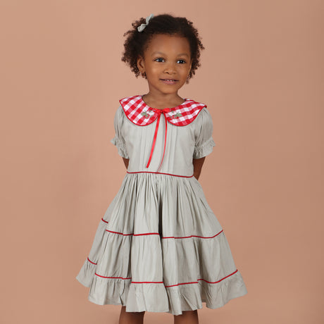 girl wearing vintage red gingham hand-embroidered collar girls dress with layered tiered skirt