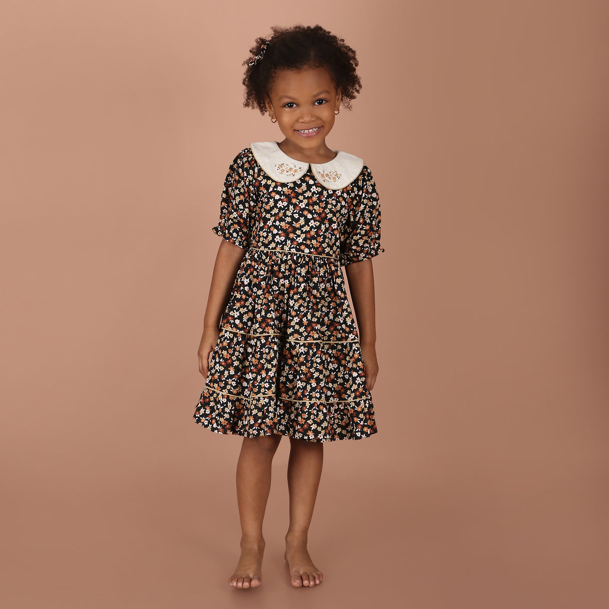 girl wearing black floral hand-embroidered collar girls dress with layered skirt