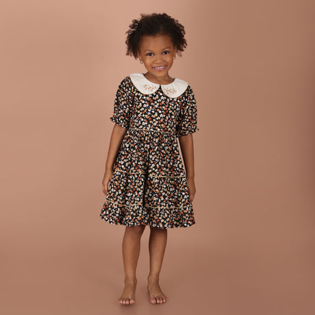 girl wearing black floral hand-embroidered collar girls dress with layered skirt