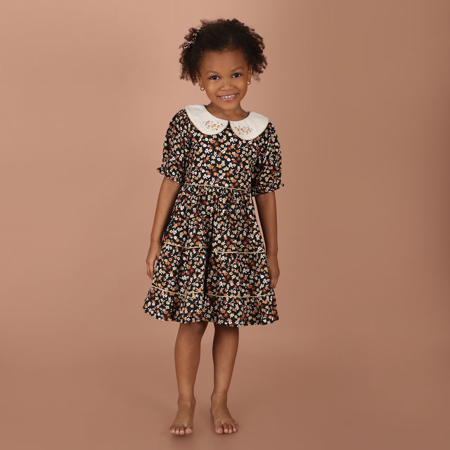 girl wearing black floral hand-embroidered collar girls dress with layered skirt