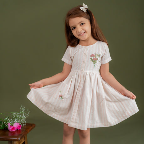 girl wearing peach stripe dress with French knot floral embroidery