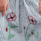 closeup of the embroidery detail in the navy striped dress