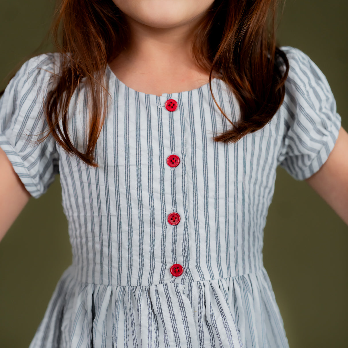 closeup of the red front buttons in the naby striped dress