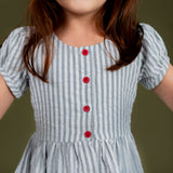 closeup of the red front buttons in the naby striped dress