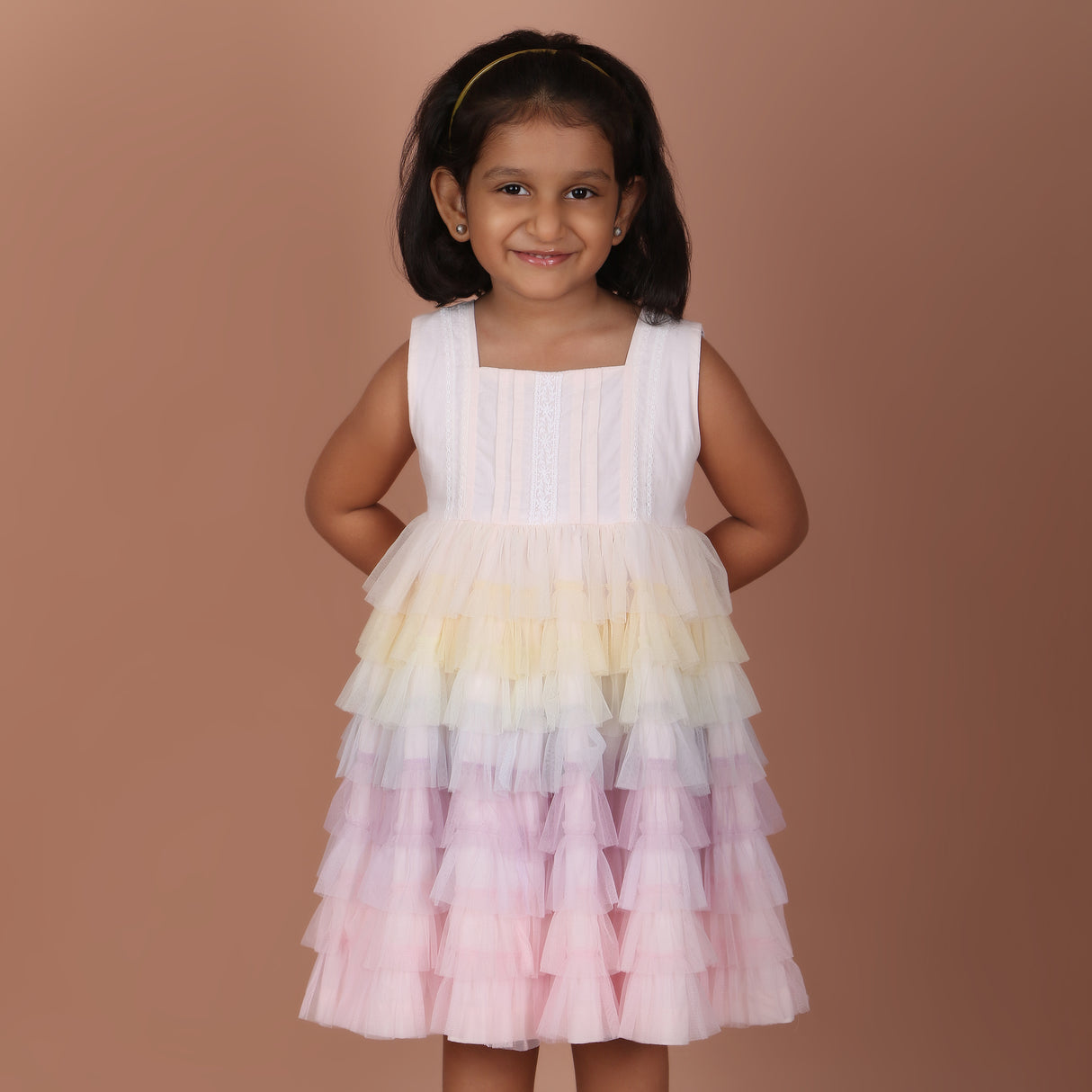 Front view of girls light pink rainbow layered tulle party dress with sleeveless design