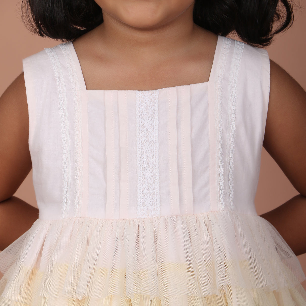 Detailed front bodice view of sleeveless rainbow tulle dress with pleat detailing