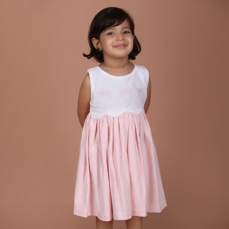 girl wearing pink bow embroidered schiffli dress