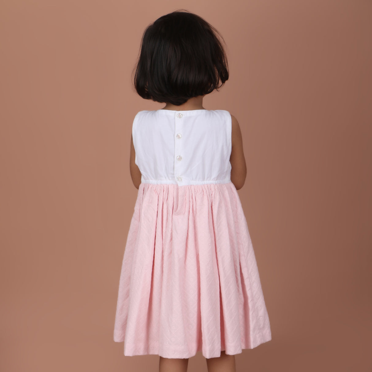 back view showing button closure and waist ties