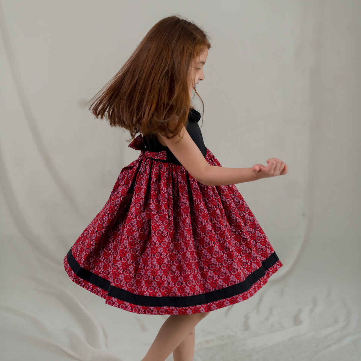 side view of girl twirling in black scallop bodice dress