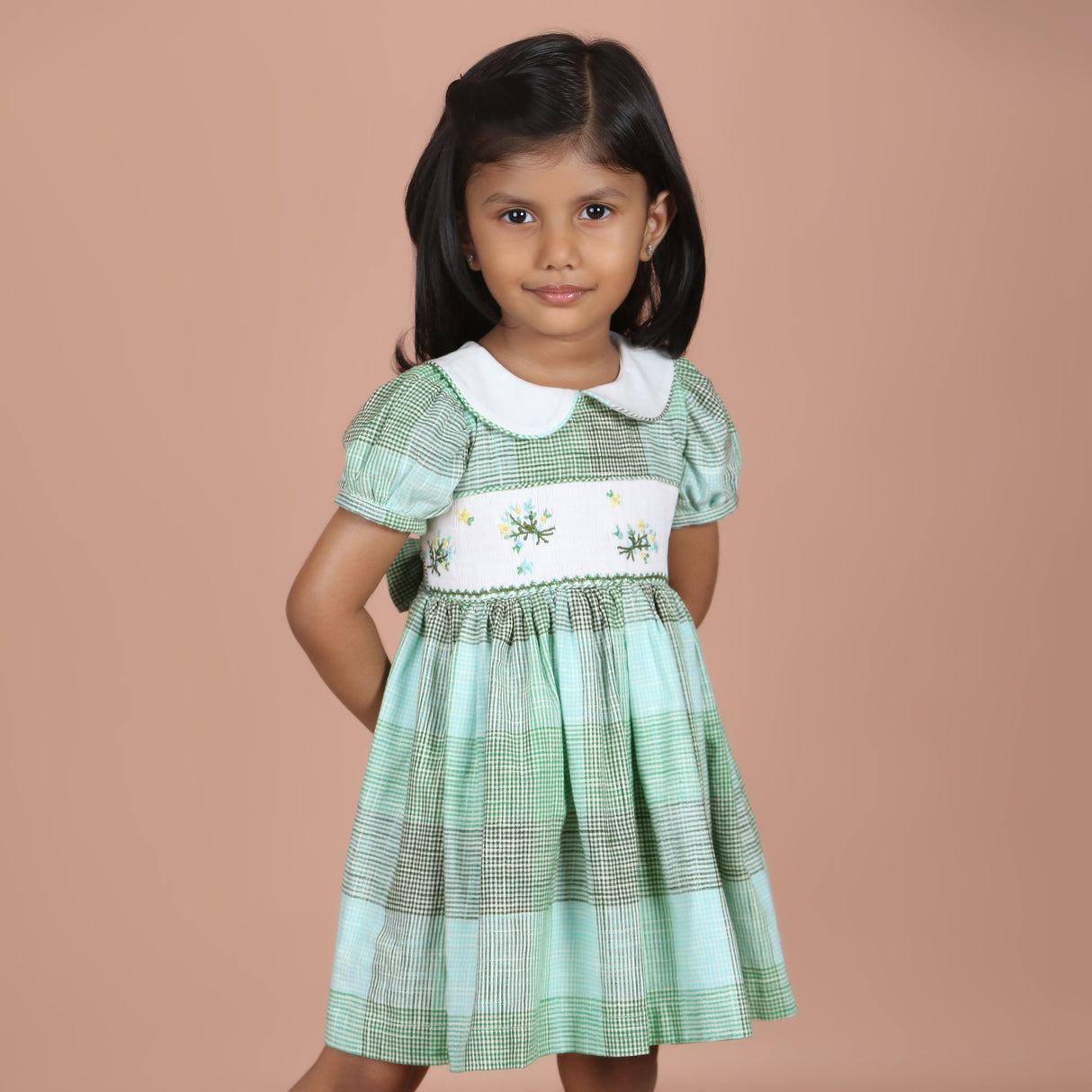 Angled front view of girls green gingham floral embroidered dress