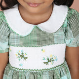 Detailed collar and bodice view of green check girls dress with floral embroidery
