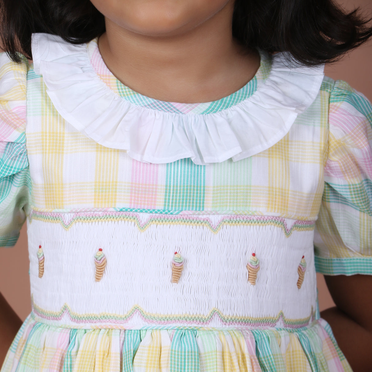 Front close-up of the plaid dress with ice cream embroidered smocked details