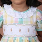 Front close-up of the plaid dress with ice cream embroidered smocked details