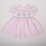 flat lay of pale pink micro dot dress with bunny embroidery