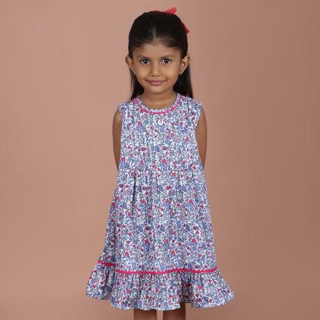 front view of girl wearing blue floral ric rac ruffle dress