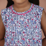 closeup of hand embroidery on button and round neckline with ric rac trim detail