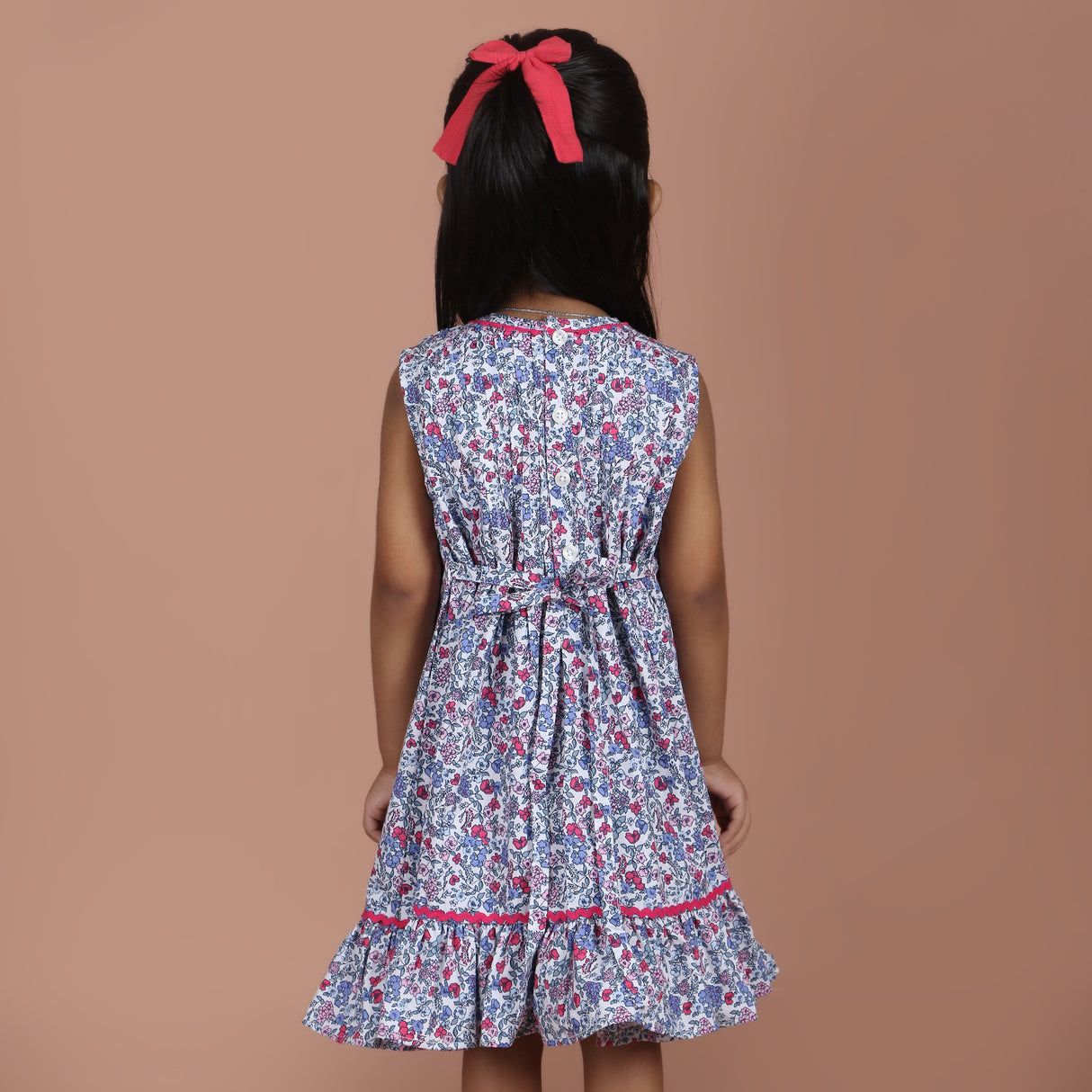 back view of blue floral girls dress with tie-up bow detail