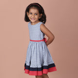 side view of girl in a navy ditsy floral dress with red waistband