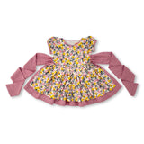 Flatlay of vintage style floral printed dress with a double layered skirt and back ties