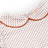 Close up of printed blouse with gathered sleeves and back button fastening with orange piping