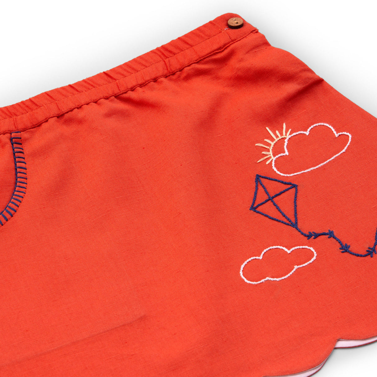 Close-up of cotton solid orange hand embroidered skirt with a scallop hem