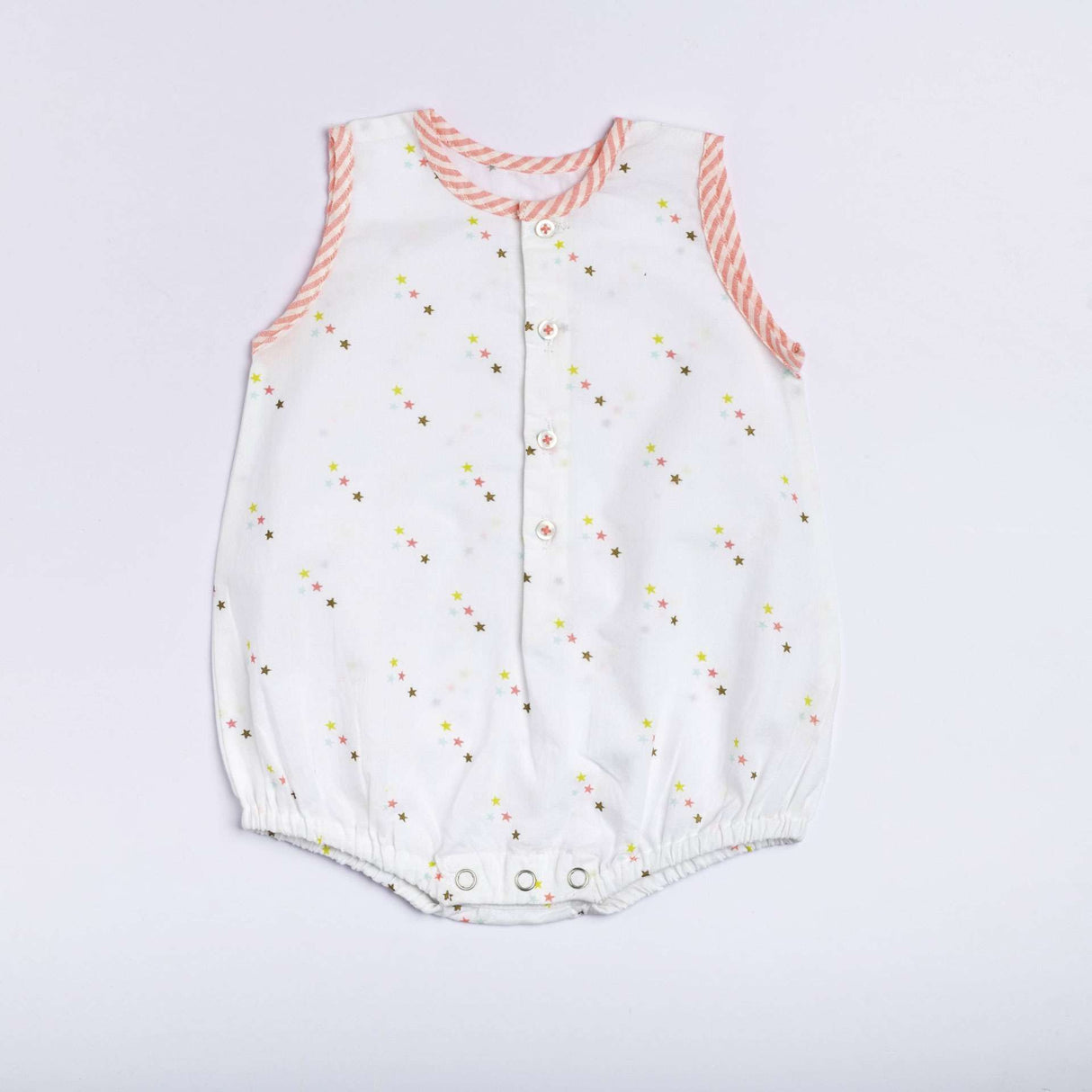 Flatlay of star print onesie with neon pink stripe piping, front open placket and button fastening