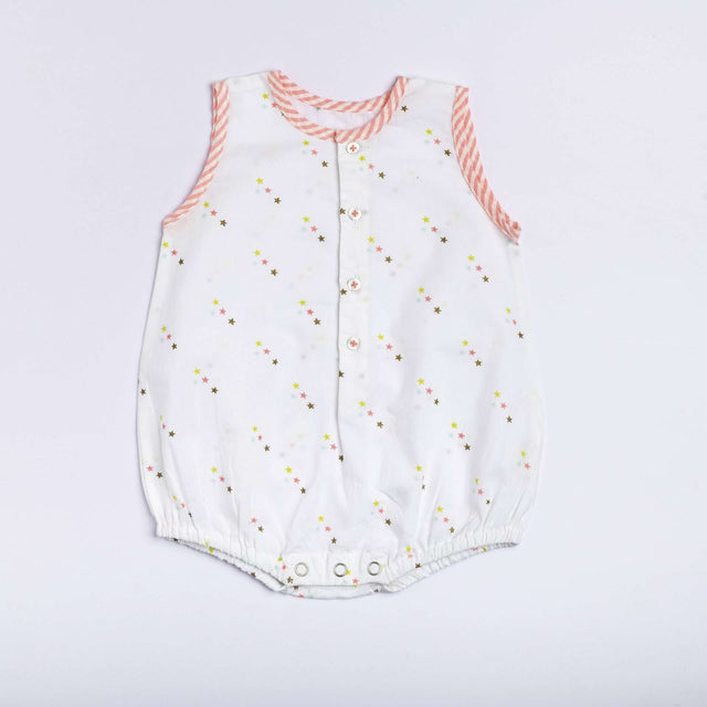 Flatlay of star print onesie with neon pink stripe piping, front open placket and button fastening