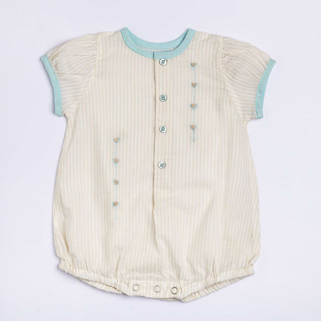 Flatlay of peaches and cream striped hand embroidered onesie for a baby girl