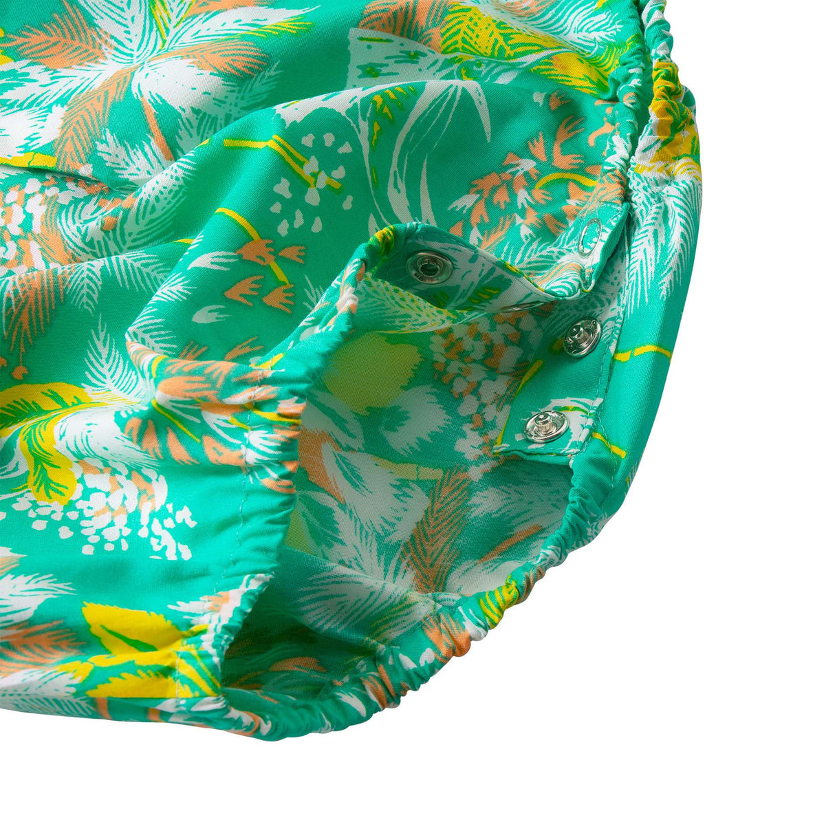 Close-up of the snap buttons on the inseams of green tropical palm leaf printed onesie