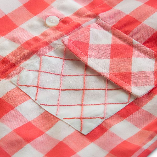 Close-up of hand embroidered pocket of red checked boys' shirt