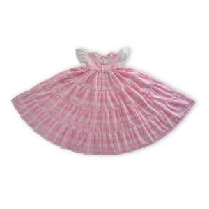Flatlay of pink plaid gown with an empire waistline and the skirt flowing in gathered tiers with delicate lace trims