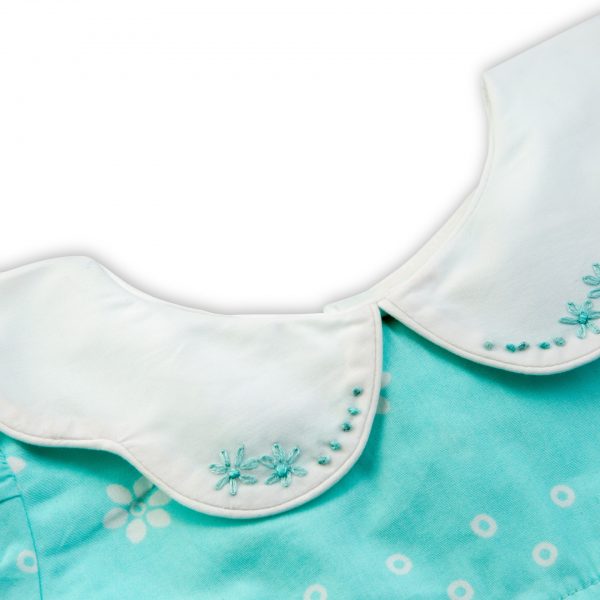 Close-up of hand embroidered collar of turquoise scallop collar dress