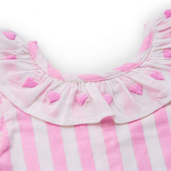 Close-up of pink A-line dress with a white embroidered neckline ruffle with matching pink heart embroidery