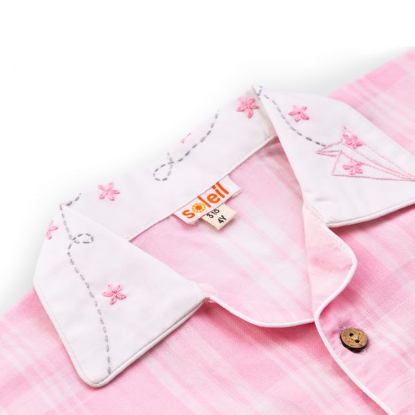 Close-up of pink plaid pyjama set with an open hand embroidered collar shirt